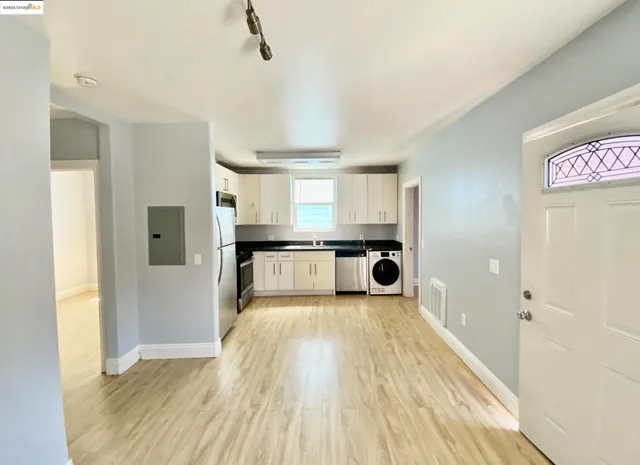 a kitchen with white cabinets and stainless steel appliances