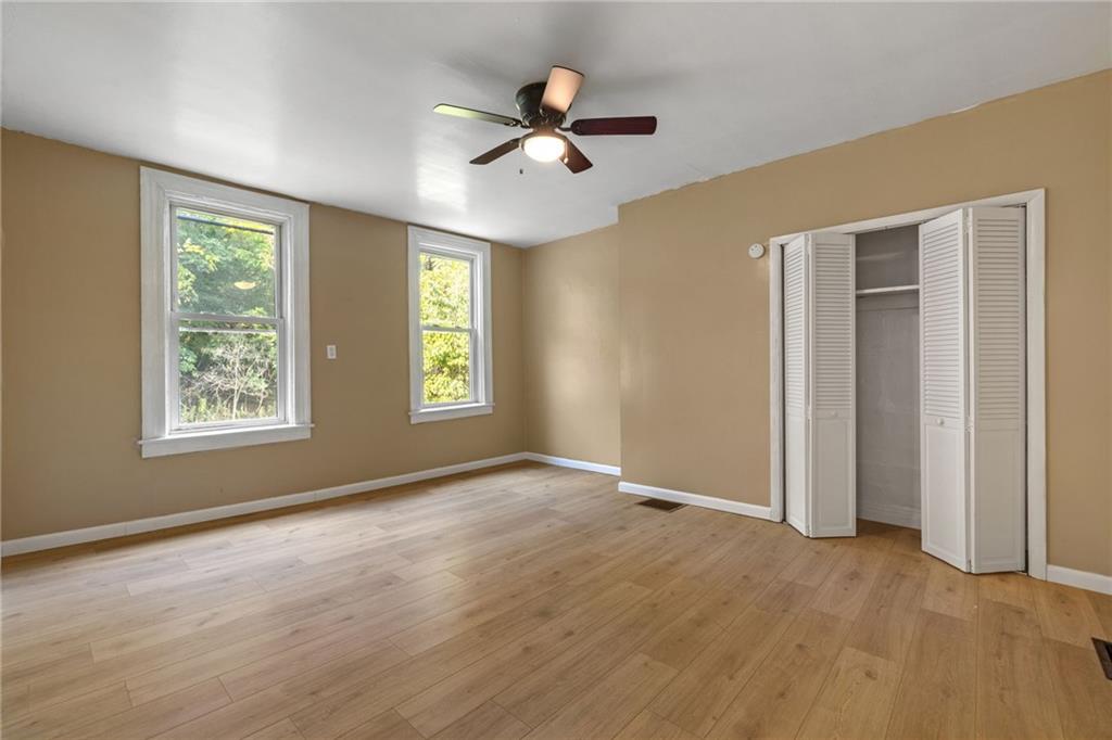 124 Silver Street Pittsburgh, PA 15209 - Photo 16 of 28 an empty room with ceiling fan and windows