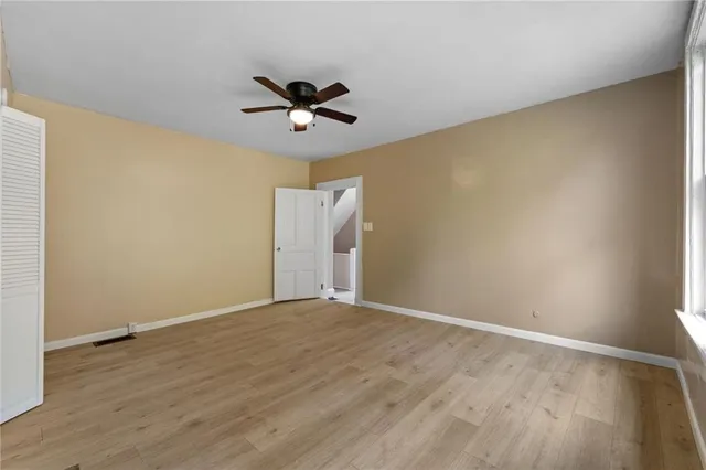 a view of room with wooden floor and ceiling fan