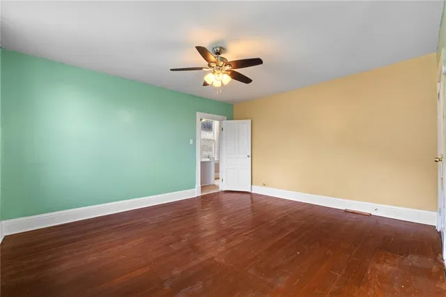 an empty room with a window and ceiling fan