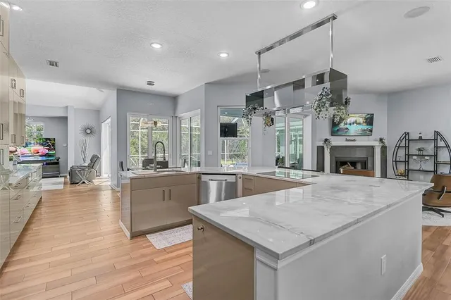 a large kitchen with kitchen island a stove a sink a counter space and wooden floor