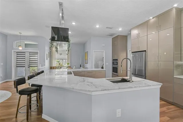 a kitchen with kitchen island a counter top space appliances and a center island