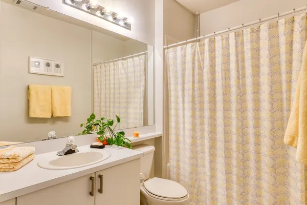 a bathroom with a sink a toilet and a window