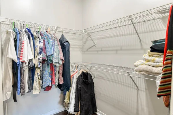 a view of walk in closet with clothes and shoes