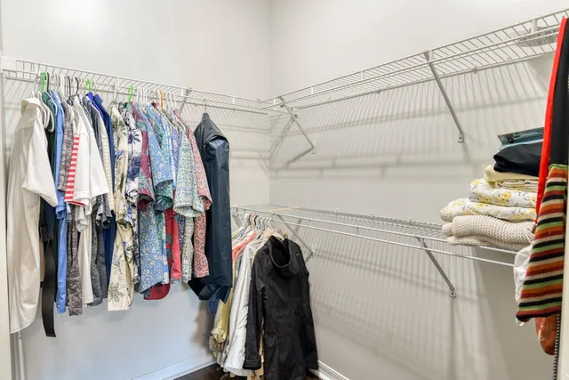 a view of walk in closet with clothes and shoes