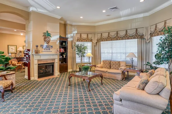 a living room with furniture a fireplace and a chandelier