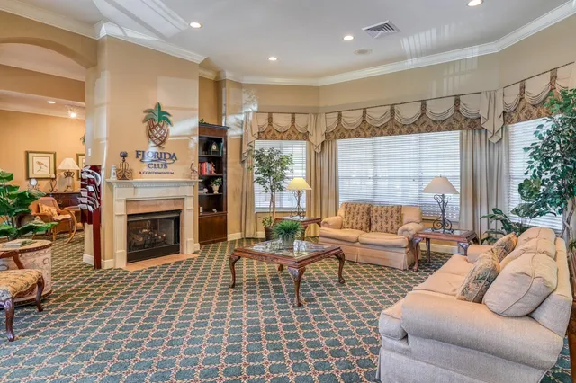a living room with furniture a fireplace and a chandelier