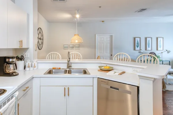 a kitchen with white cabinets and sink