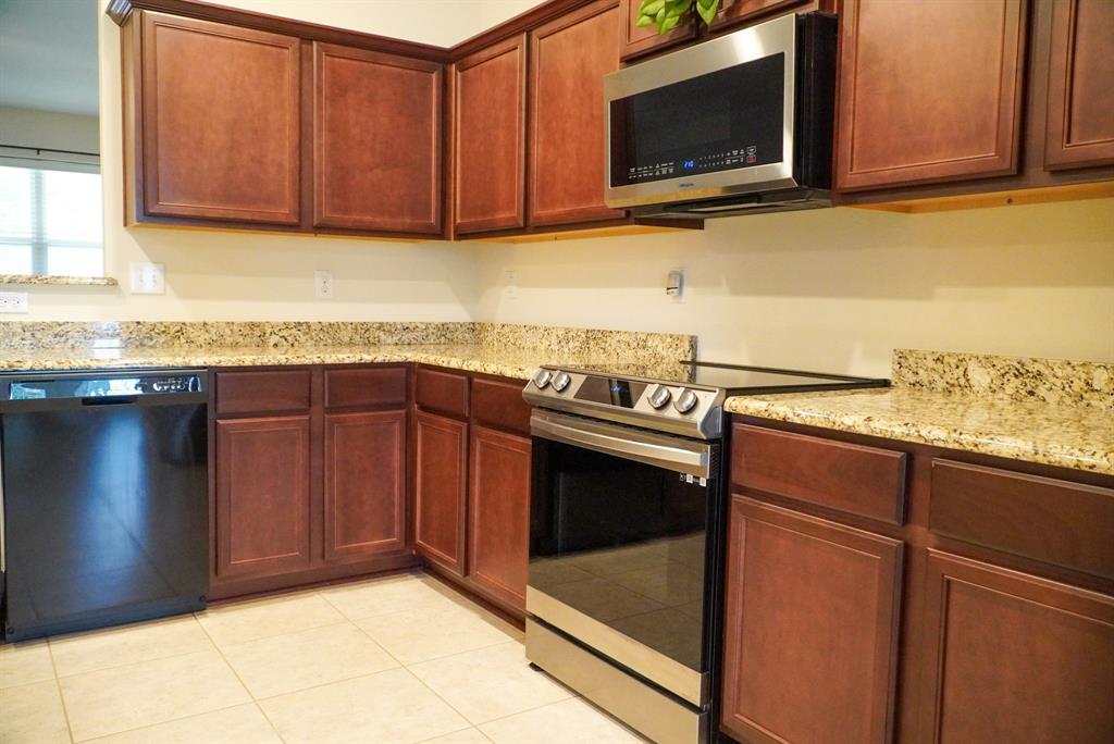 13624 Helix Bridge Way Crowley, TX 76036 - Photo 10 of 25 a kitchen with stainless steel appliances granite countertop a sink stove and microwave