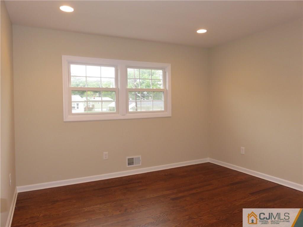 58 Harmon Road Edison, NJ 08837 - Photo 13 of 20 an empty room with wooden floor and windows