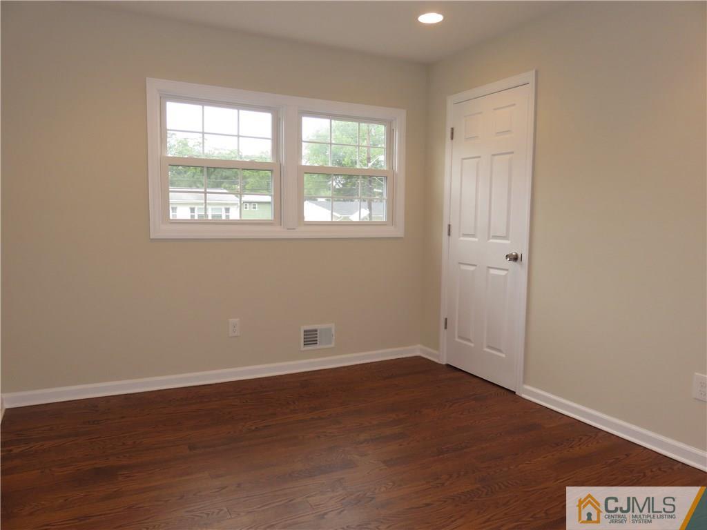 58 Harmon Road Edison, NJ 08837 - Photo 14 of 20 an empty room with wooden floor and windows