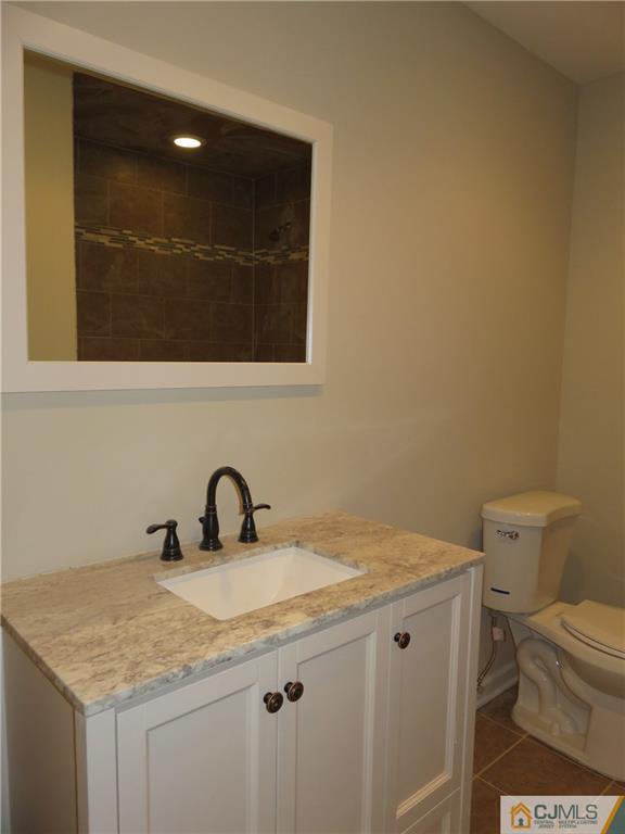 58 Harmon Road Edison, NJ 08837 - Photo 15 of 20 a bathroom with a granite countertop sink and a toilet