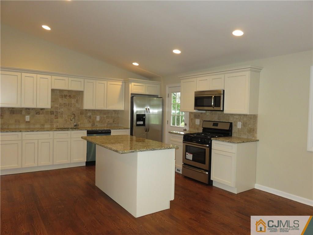 58 Harmon Road Edison, NJ 08837 - Photo 5 of 20 a kitchen with a sink a stove top oven a counter space and cabinets