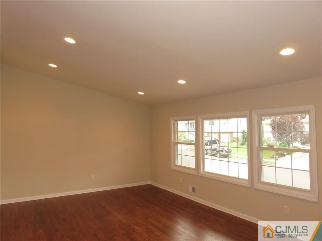 58 Harmon Road Edison, NJ 08837 - Photo 8 of 20 an empty room with wooden floor and windows