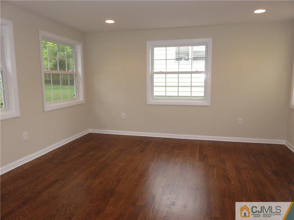 58 Harmon Road Edison, NJ 08837 - Photo 9 of 20 an empty room with wooden floor and windows