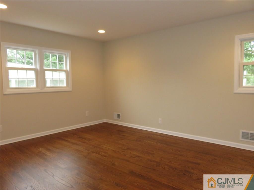 58 Harmon Road Edison, NJ 08837 - Photo 10 of 20 an empty room with wooden floor and windows