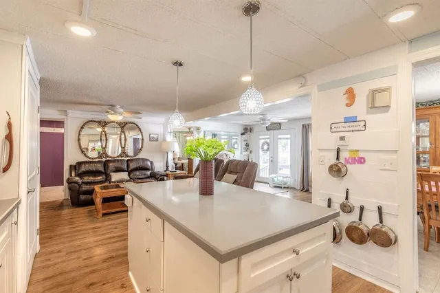 a kitchen with stainless steel appliances granite countertop a sink a oven a dining table and chairs with wooden floor