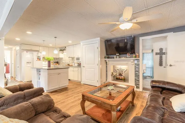 a living room with furniture a flat screen tv and kitchen view