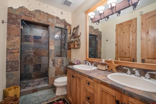 a bathroom with a granite countertop sink toilet a mirror and shower