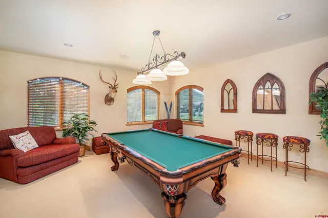 a living room with furniture pool table and a large window