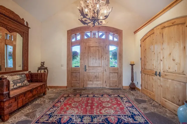 a view of a hallway with wooden floor and a chandelier