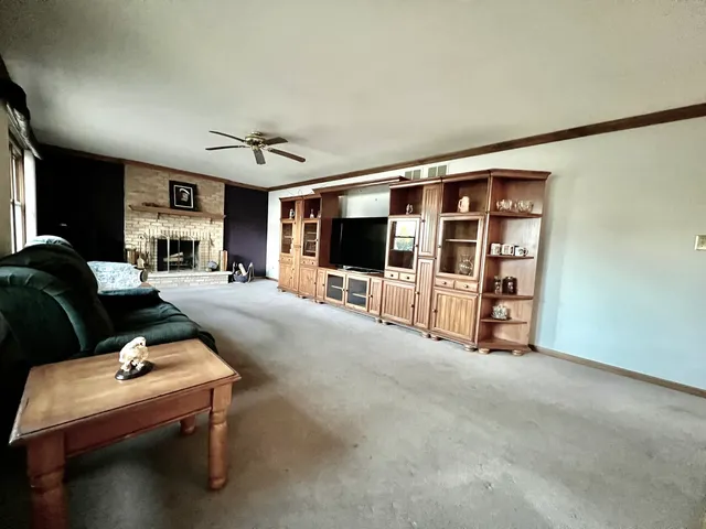 a living room with furniture a flat screen tv and floor to ceiling window