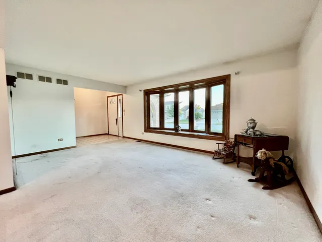 a view of an empty room with furniture and a window