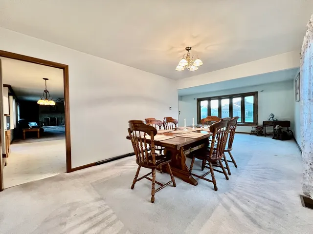 a view of a dining room with furniture and a chandelier