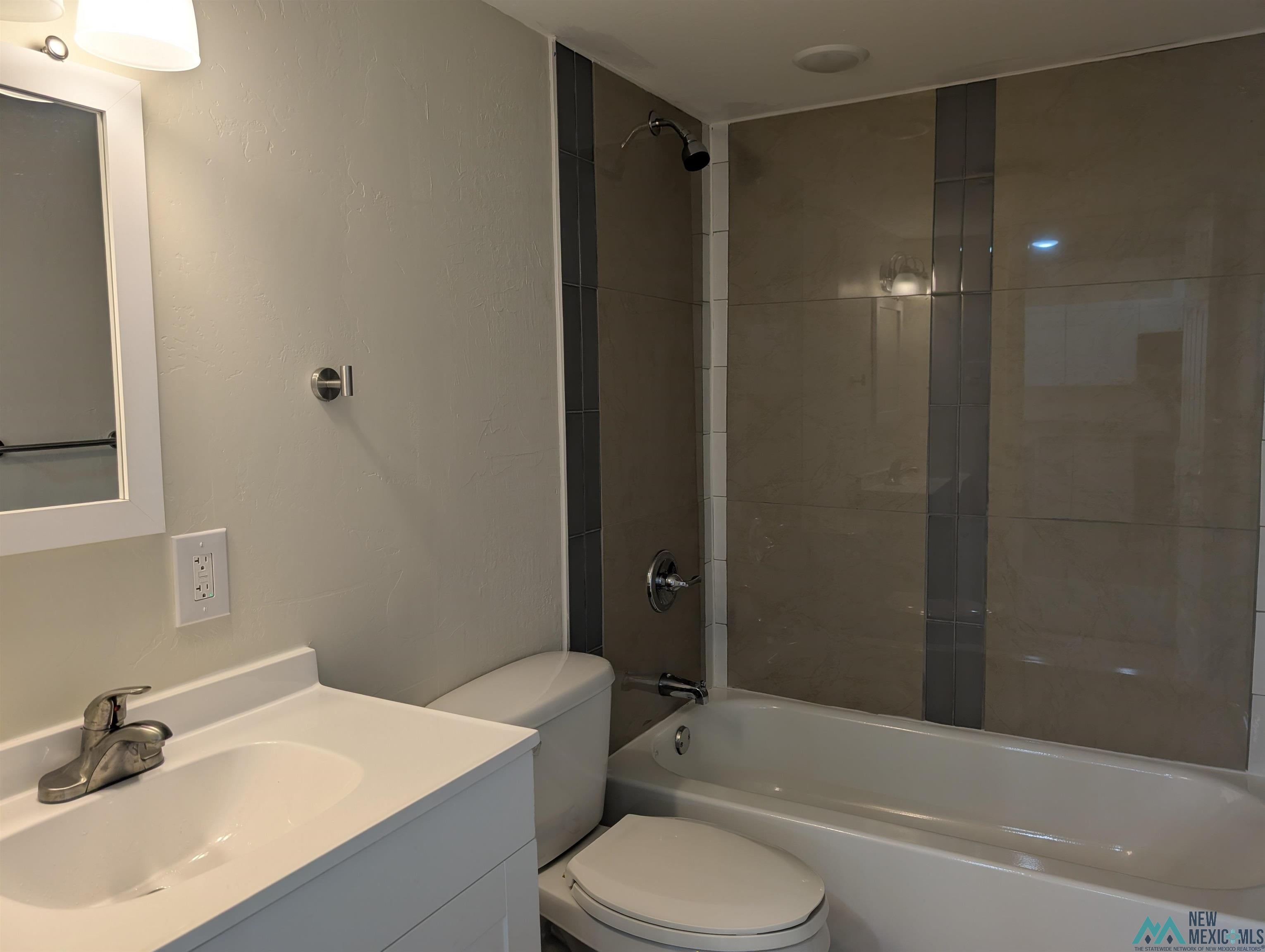 506 Bass Road Elephant Butte, NM 87935 - Photo 15 of 23 Bathroom featuring a white vanity with integrated sink, chrome faucet, and a white framed mirror
