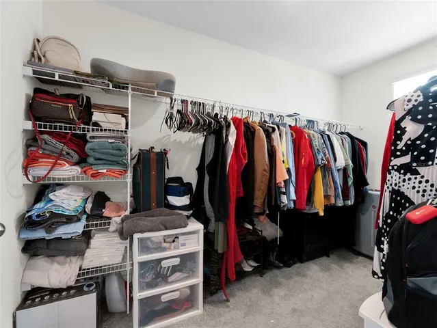 a view of walk in closet with clothes and shoes