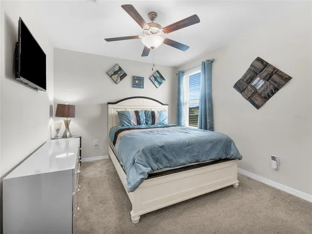 a spacious bedroom with a bed and a flat screen tv