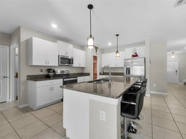 a kitchen with cabinets and chairs