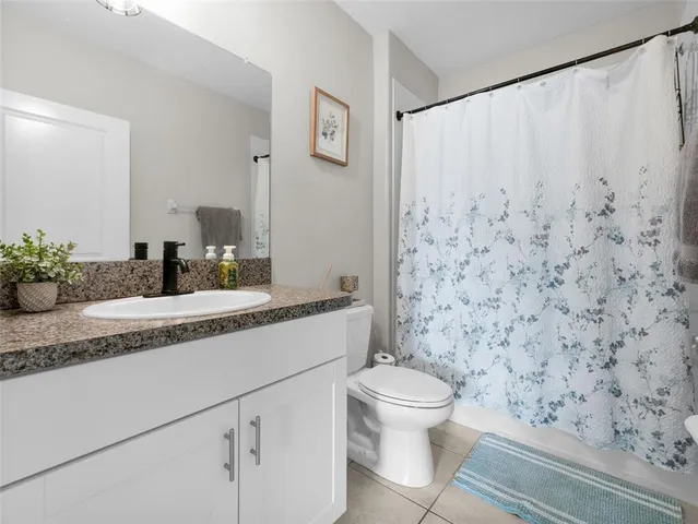 a bathroom with a granite countertop sink a toilet and a mirror