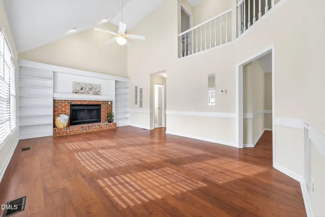wooden floor fireplace and windows in an empty room
