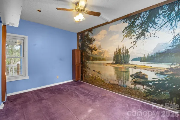 an empty room with closet and a chandelier fan