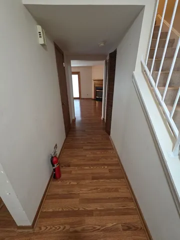a view of a hallway with wooden floor and staircase
