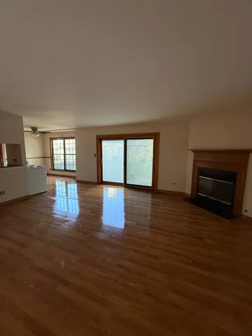 a view of empty room with wooden floor and fireplace