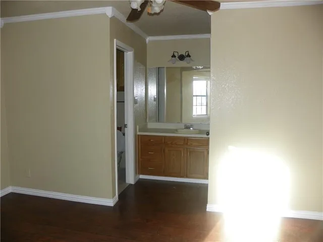 an empty room with a window and ceiling fan