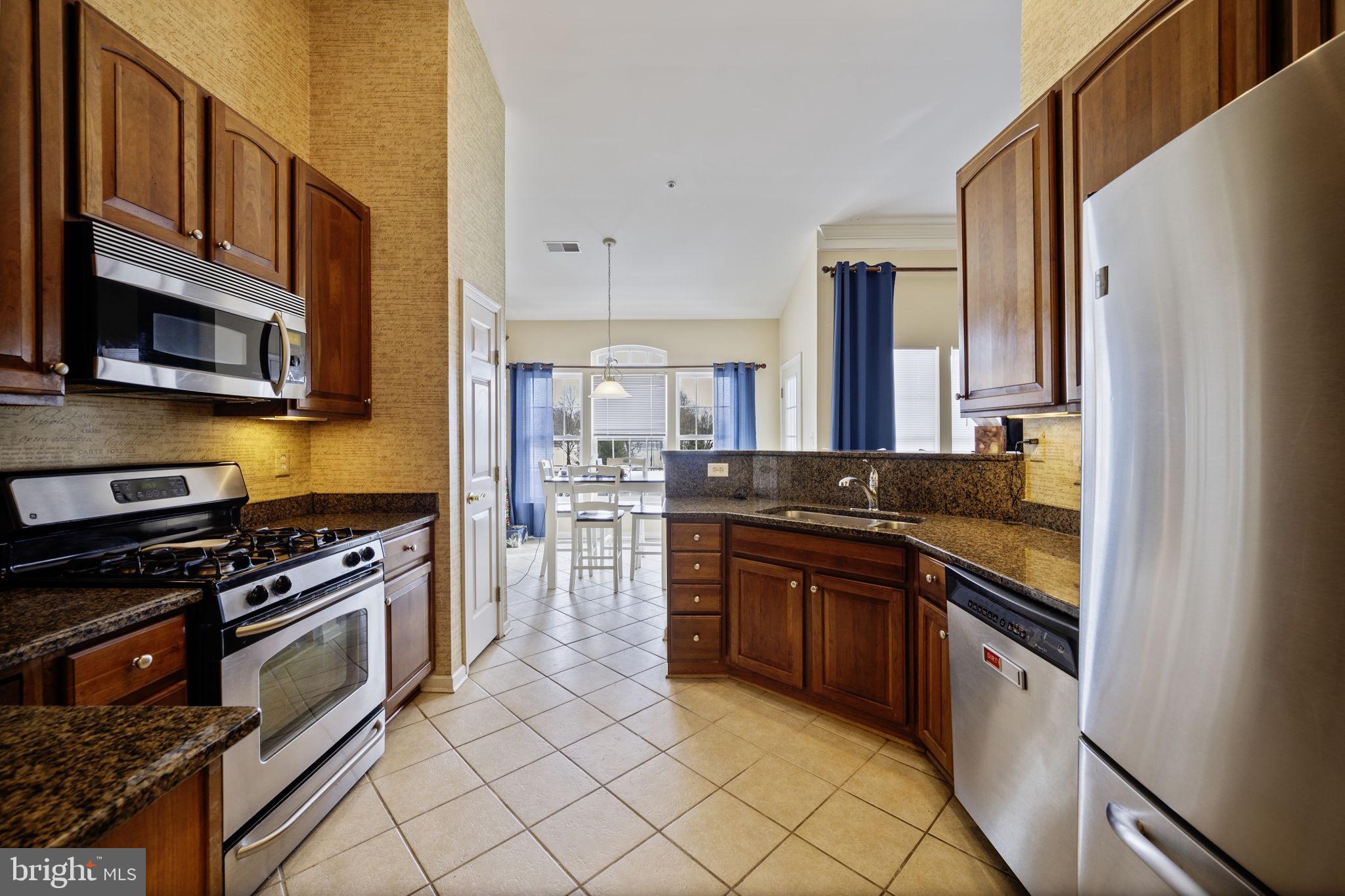2602 Clarion Court, Unit 404 Odenton, MD 21113 - Photo 16 of 38 a kitchen with stainless steel appliances granite countertop a stove and a refrigerator