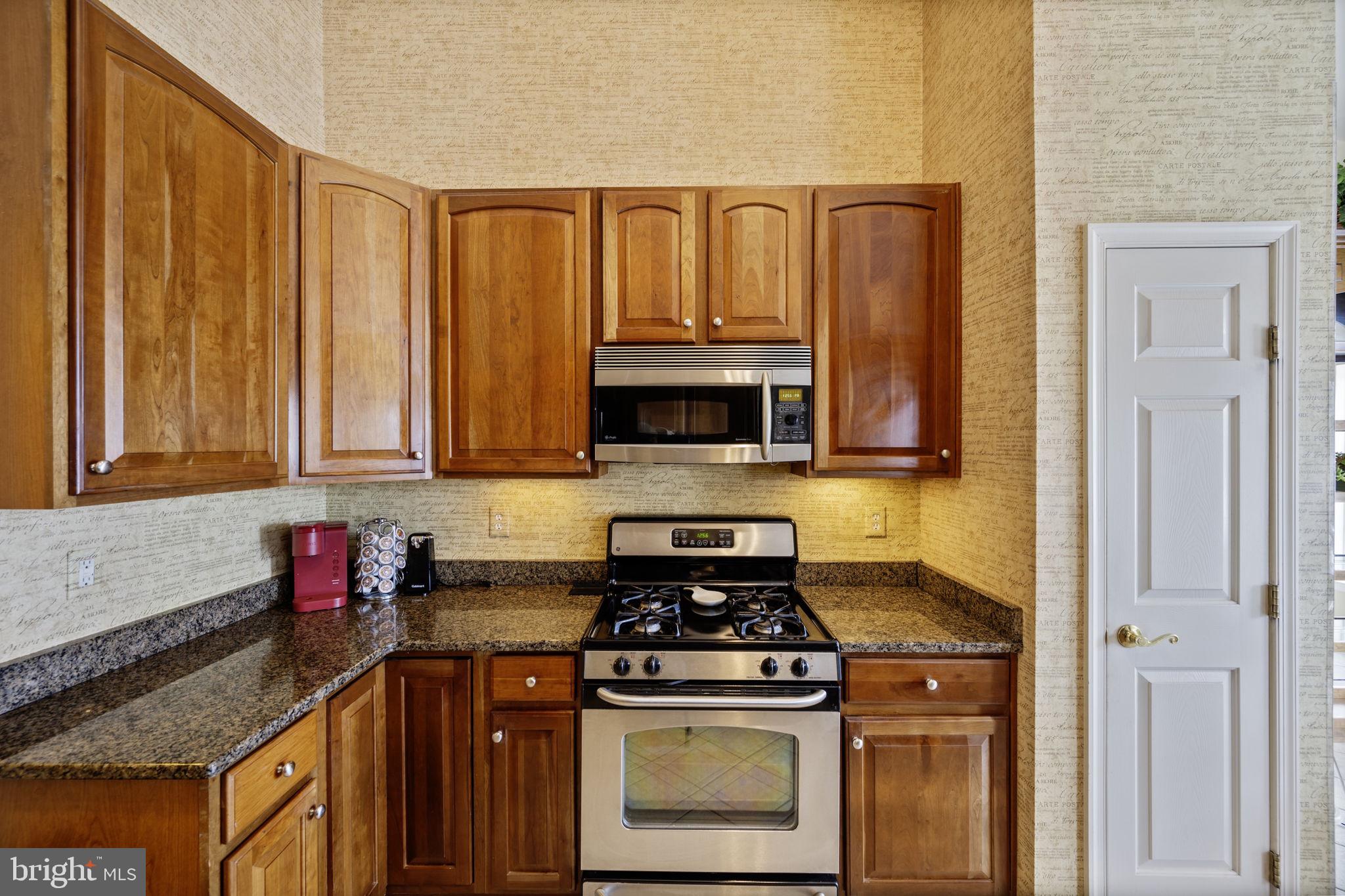 2602 Clarion Court, Unit 404 Odenton, MD 21113 - Photo 17 of 38 a kitchen with stainless steel appliances granite countertop a stove a sink and a microwave