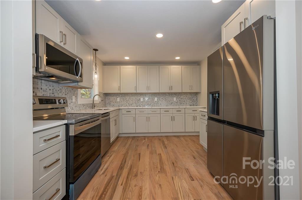 438 Gilbert Road Columbus, NC 28722 - Photo 13 of 46 a kitchen with stainless steel appliances a refrigerator sink and microwave