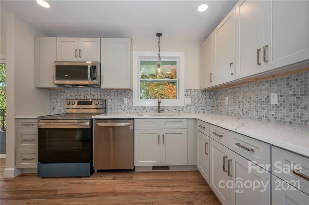 438 Gilbert Road Columbus, NC 28722 - Photo 14 of 46 a kitchen with white cabinets stainless steel appliances and sink