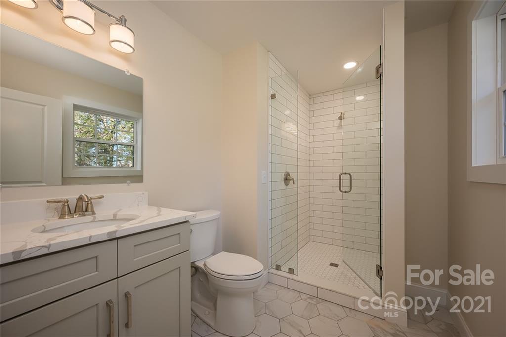 438 Gilbert Road Columbus, NC 28722 - Photo 21 of 46 a bathroom with a shower sink vanity mirror and toilet