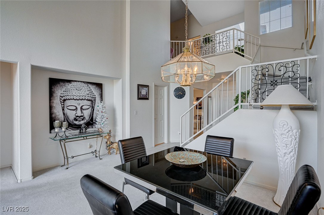516 Crimson View Place Las Vegas, NV 89144 - Photo 13 of 66 Dining area with carpet floors, a towering ceiling, a chandelier, and stairway