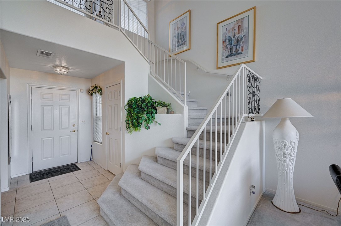 516 Crimson View Place Las Vegas, NV 89144 - Photo 14 of 66 Entrance foyer featuring a high ceiling, light tile patterned floors, stairs, and healthy amount of natural light