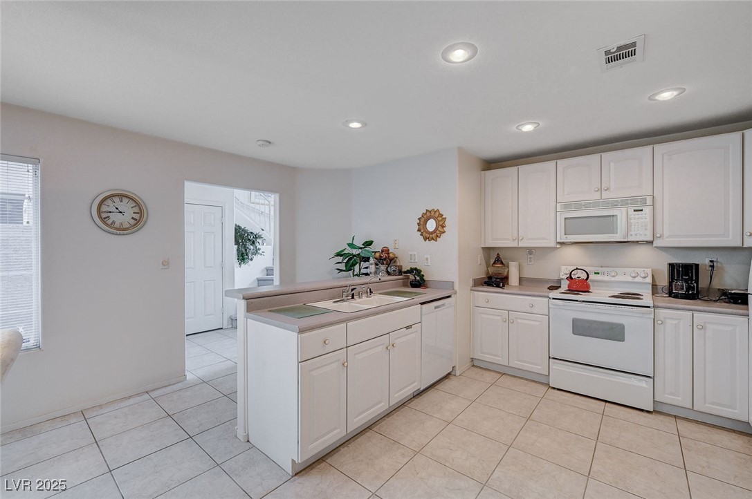 516 Crimson View Place Las Vegas, NV 89144 - Photo 22 of 66 Kitchen with white appliances, white cabinetry, light tile patterned flooring, recessed lighting, and light countertops