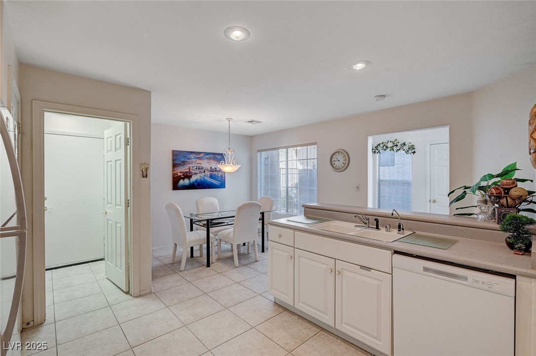 516 Crimson View Place Las Vegas, NV 89144 - Photo 23 of 66 Kitchen with white dishwasher, hanging light fixtures, light tile patterned floors, a peninsula, and light countertops