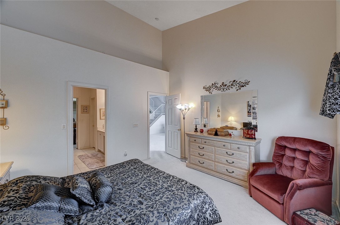 516 Crimson View Place Las Vegas, NV 89144 - Photo 28 of 66 Bedroom featuring light colored carpet, a towering ceiling, and ensuite bath