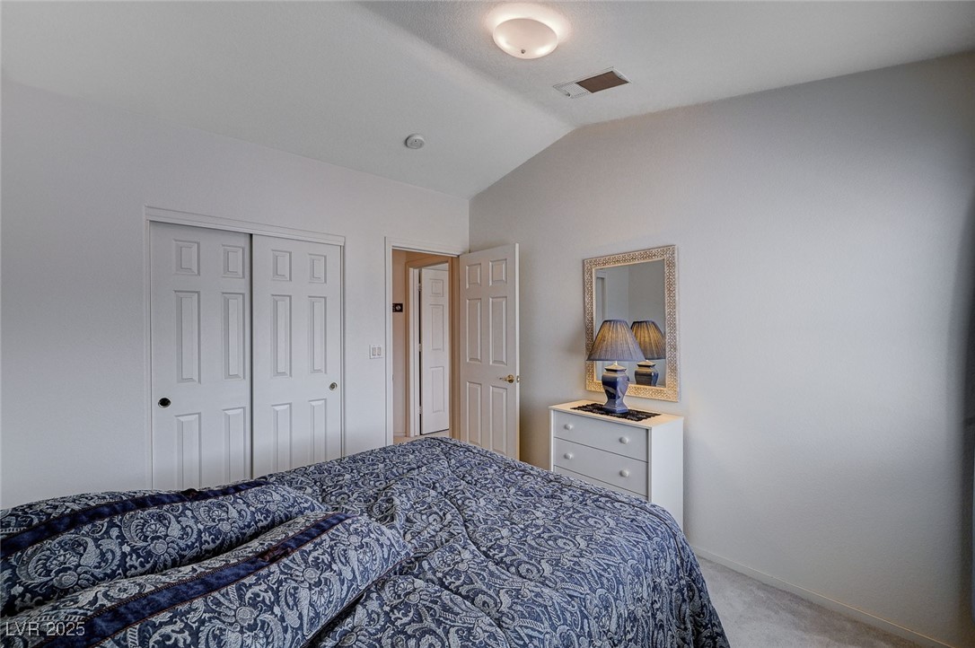 516 Crimson View Place Las Vegas, NV 89144 - Photo 42 of 66 Bedroom featuring light colored carpet, lofted ceiling, and a closet