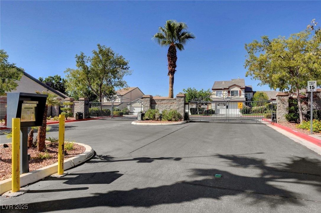 516 Crimson View Place Las Vegas, NV 89144 - Photo 58 of 66 View of asphalt street with curbs, a gated entry, traffic signs, and a gate